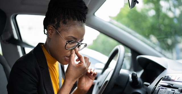 Women in car blowing her nose